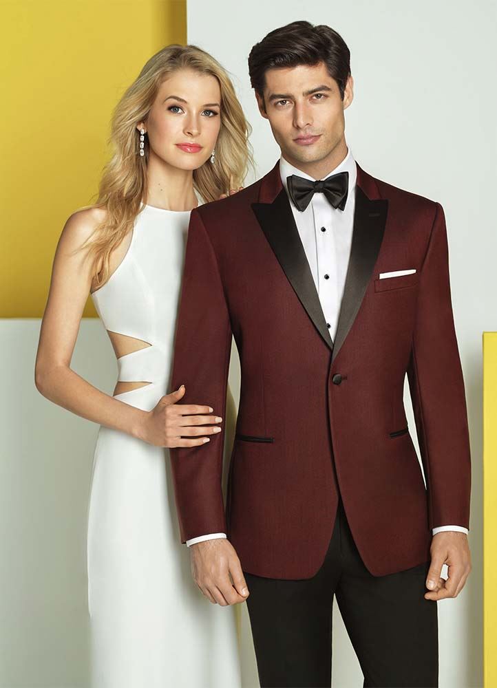 Man in tuxedo with model by his side
